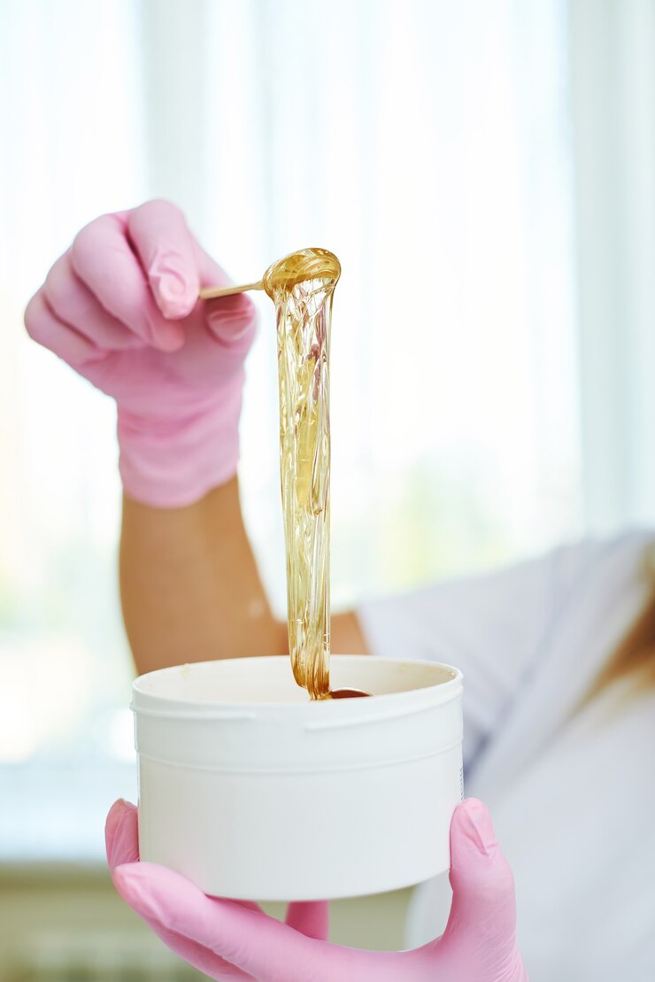 Cosmétologue tenant peut avec de la pâte à sucre