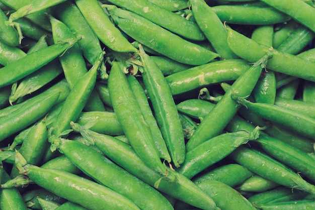 Cosses de pois frais comme toile de fond. Vue de dessus.