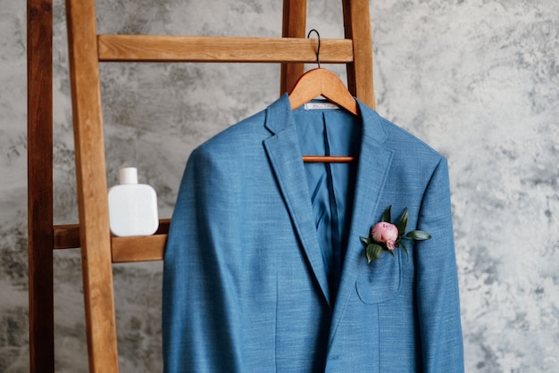 Photo costume classique blazer bleu accroché sur une échelle en bois