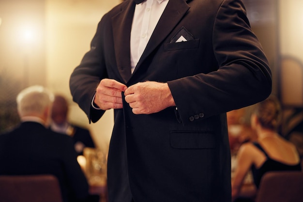 Costume formel et homme nouer le bouton de sa veste lors d'un dîner ou d'un banquet chic Élégance chic et blazer de fixation masculin de sa tenue élégante lors d'un souper classique ou d'un rassemblement