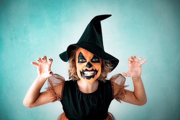 Costume de sorcière habillé pour enfant drôle. Kid a peint une terrible citrouille. Concept de vacances d'automne Halloween