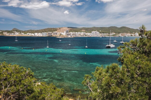 Côte de la baie d'ibiza avec eau turquoise et yachts le jour d'été ensoleillé vue sur le port de sant ...