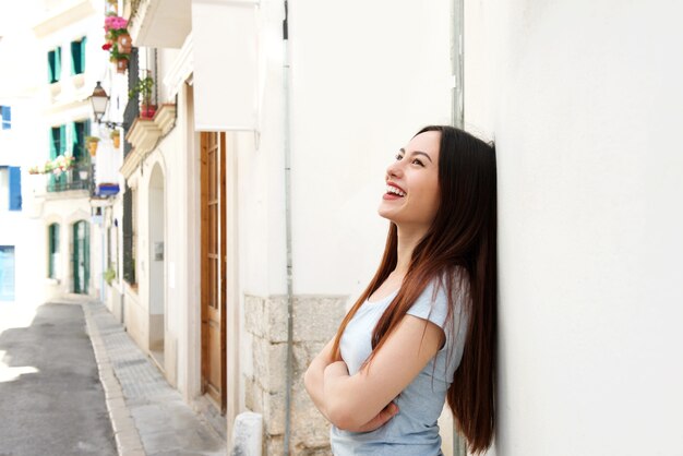 Côté, beau, femme, debout, rue, rire, bras croisés