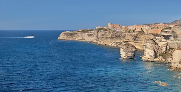 Côte de Bonifacio avec falaise de calcaire dans la mer sous un ciel bleu clair en Corse France