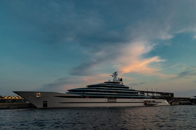 Le côté gauche d'un immense yacht dans le port de monaco au coucher du soleil à bord brillant du bateau à moteur le chrome pl...