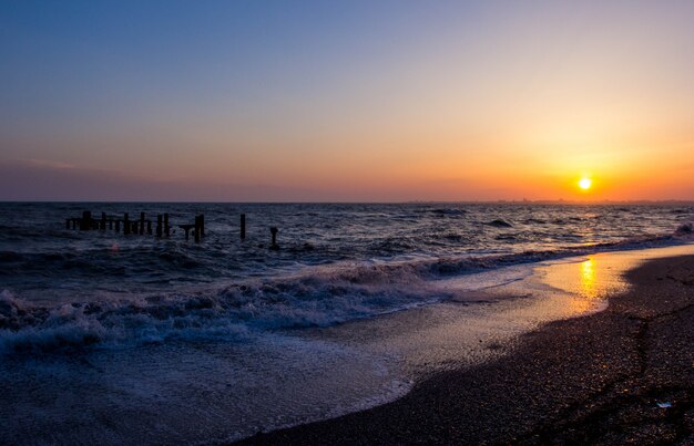 Côte de la mer au coucher du soleil. Vagues.