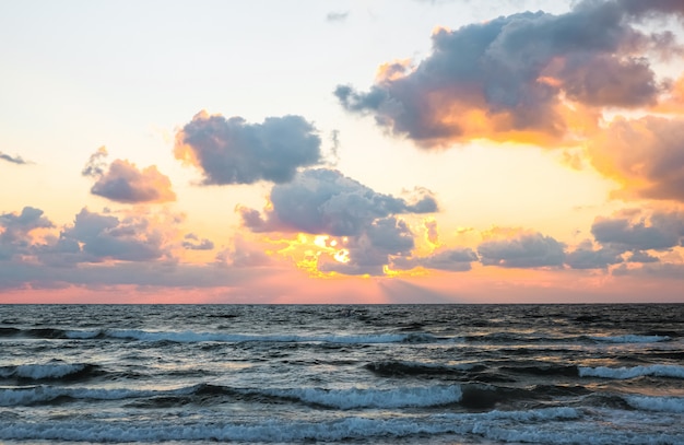 Côte de la mer avec des vagues au coucher du soleil