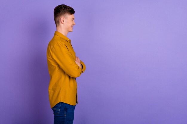 Côté profil photo de jeune homme les mains jointes regarder l'espace vide patron chef isolé sur fond de couleur violette