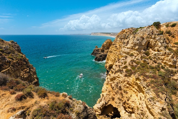 Côte rocheuse d'été de l'océan Atlantique voir Ponta da Piedade Lagos Algarve Portugal Les gens dans les bateaux à moteur sont méconnaissables