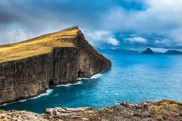 Une côte rocheuse avec une mer bleue et des montagnes en arrière-plan
