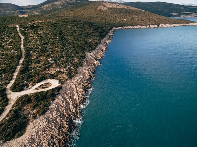 Côte rocheuse de la péninsule de Lustica au Monténégro drone aérien vue des vagues mousseuses frapper la côte