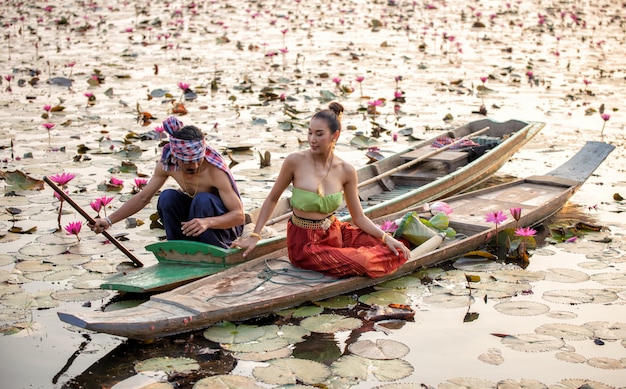 Photo côté, vue, homme, donner, lotus, à, femme, sur, bateau, dans, lac