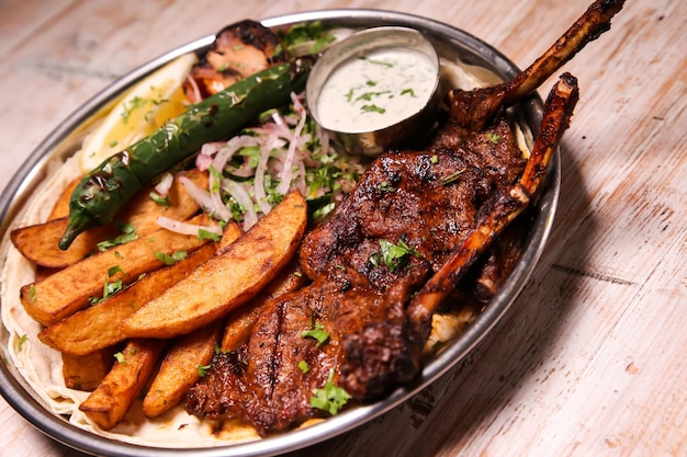 Côtelette d'agneau Riyash avec des quartiers de salade citron et trempette servis dans un plat isolé sur fond vue de dessus de la nourriture arabe