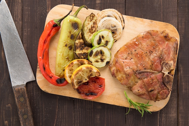 Côtelette de porc grillée et légumes sur fond de bois