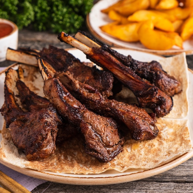 Côtelettes d'agneau grillées sur une assiette. Mouton sur un gril. Fermer