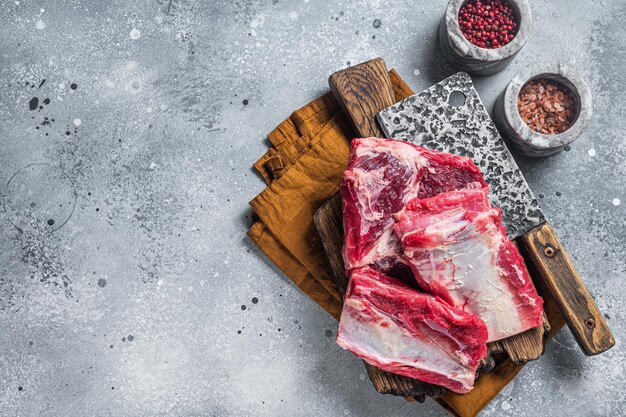 Côtes courtes de veau de boeuf kalbi, viande crue sur planche de boucher en bois. Fond gris. Vue de dessus. Espace de copie.