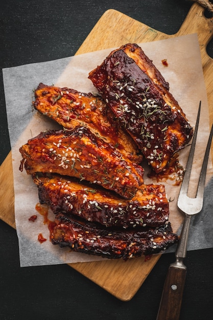 Côtes levées barbecue grillés sur la planche à découper, vue de dessus. Côtes de porc rôties fumées traditionnelles américaines