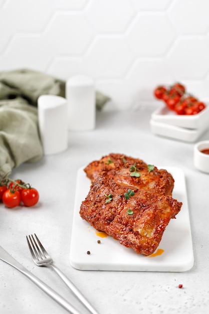 Côtes levées cuites au barbecue de porc mariné sur une planche à découper en céramique blanche et un fond gris blanc Copier l'espace