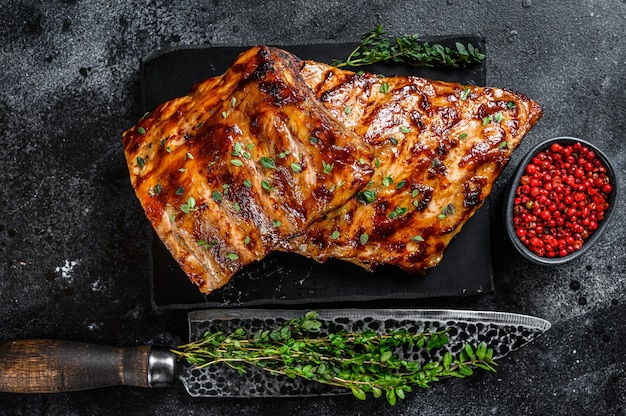 Côtes levées de grille de porc barbecue sur une planche de marbre.