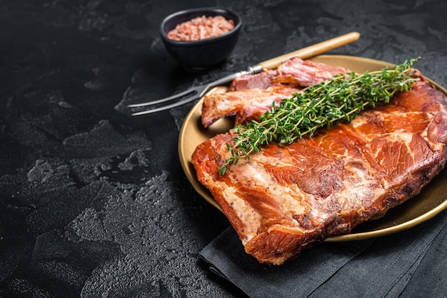 Côtes levées de porc grillées au barbecue sur plaque d'acier au thym Fond noir Vue de dessus Espace de copie