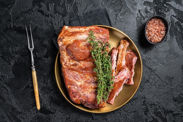 Côtes levées de porc grillées au barbecue sur plaque d'acier au thym Fond noir Vue de dessus