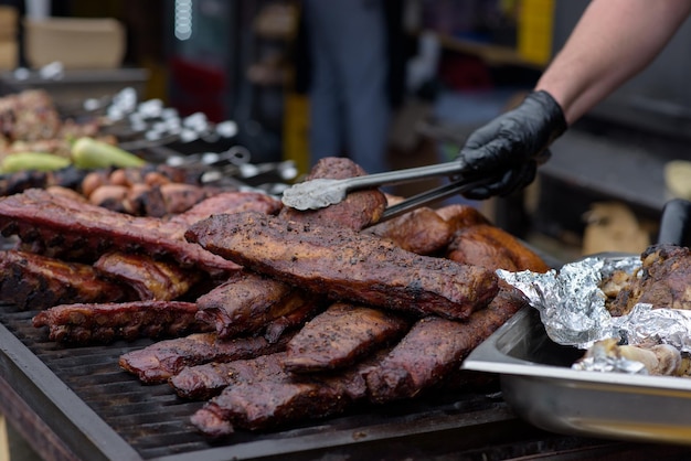 Côtes levées de porc grillées avec sauce barbecue sur le gril Cuisine de rue du festival