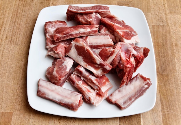 Côtes levées de porc non cuites sur un plat blanc