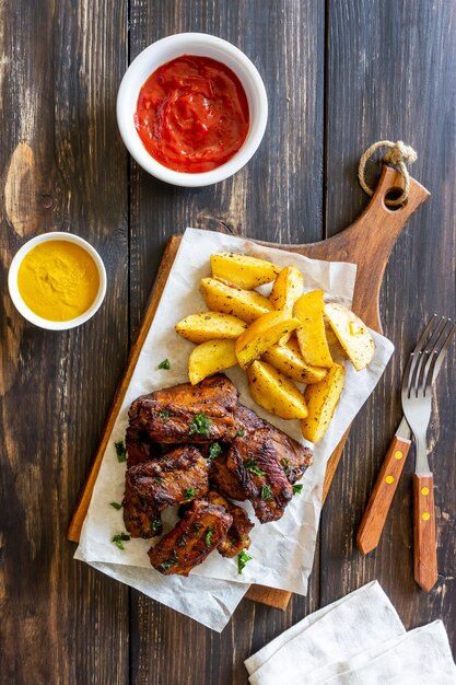 Côtes de porc aux pommes de terre sur une table en bois. Barbecue. Gril. Cuisine américaine. Recette.