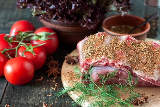 Côtes de porc crues aux légumes sur une table en bois