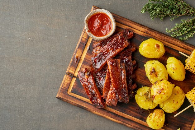 Côtes de porc épicées au barbecue, épis de maïs et pommes de terre écrasées écrasées. Cuisine américaine. Vue de dessus, espace copie