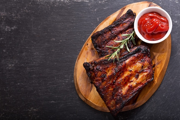 Côtes de porc grillées au romarin sur planche de bois, vue du dessus