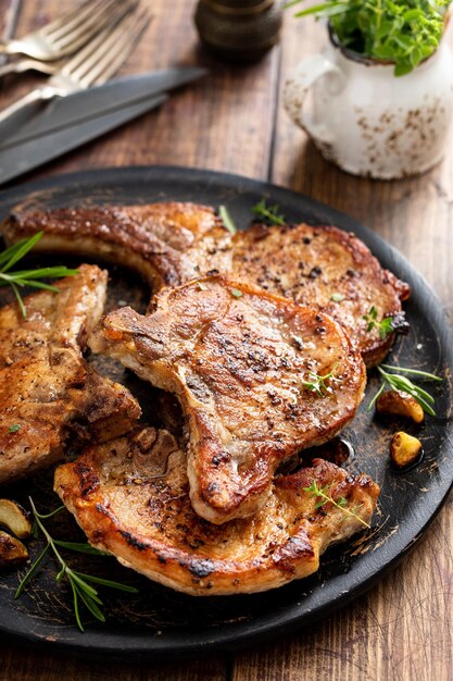 Photo côtes de porc grillées ou frites à la poêle à l'os