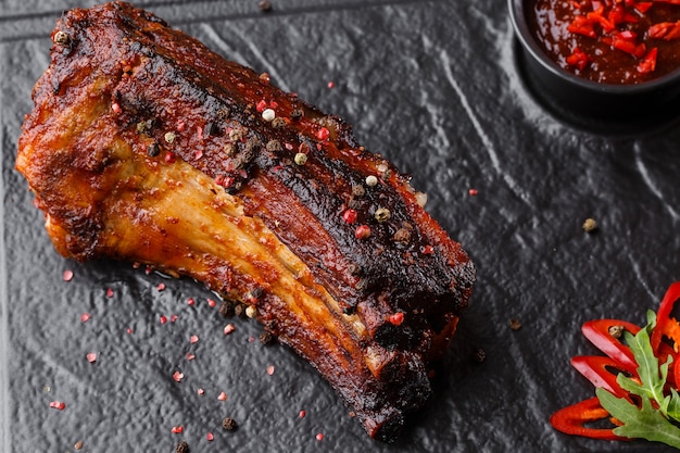 Côtes de porc grillées et grillées au piment fort et sauce piquante sur pierre noire