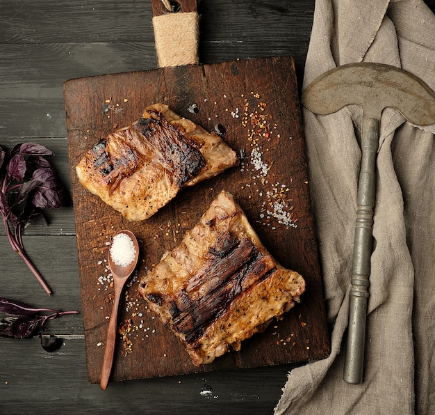 Côtes de porc grillées sur une planche à découper en bois marron