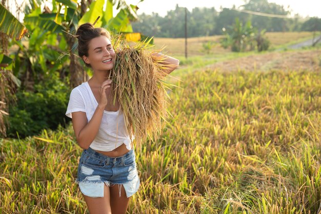 Écotourisme ou travail quotidien. Happy woman farmer lors de la récolte sur le champ de riz