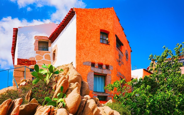 Cottage et paysage à Porto Cervo sur l'île italienne de Sardaigne en été. Villa et vue paysage sur ville sarde en Sardaigne. Province d'Olbie. Technique mixte.