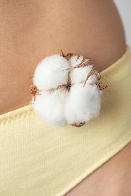 Photo cotton flower in female hands the concept of intimate hygiene clothing made from natural fabrics