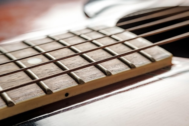 Cou avec cordes et gros plan du corps sur une vieille guitare acoustique classique sous éclairage naturel