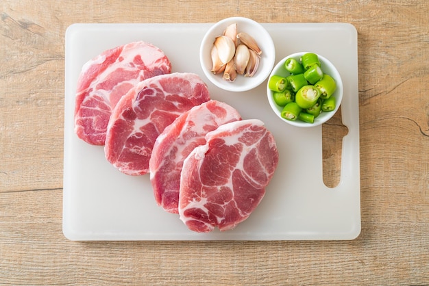 Cou de porc frais cru ou col de porc à bord avec des ingrédients pour mariné