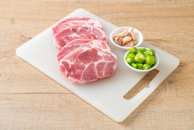 Cou de porc frais cru ou col de porc à bord avec des ingrédients pour mariner