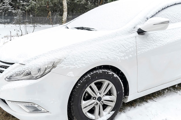 Couche de neige fraîche sur la fenêtre du pare-brise du pare-brise de la voiture dans l'allée parking spot automobile dans le blizzard neige tempête de neige en hivervéhicule par temps extrême