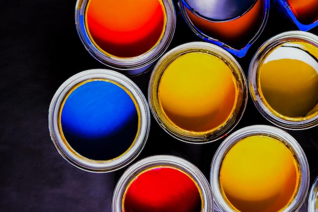 Une couche plate de boîtes de peinture ouvertes de différentes couleurs