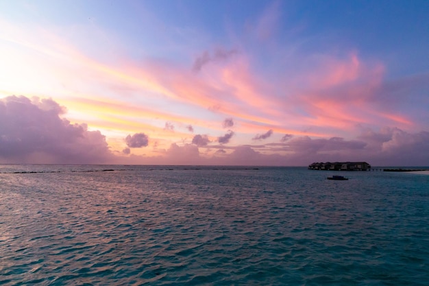 Coucher du soleil des Maldives avec des couleurs roses et des nuages rougeâtres