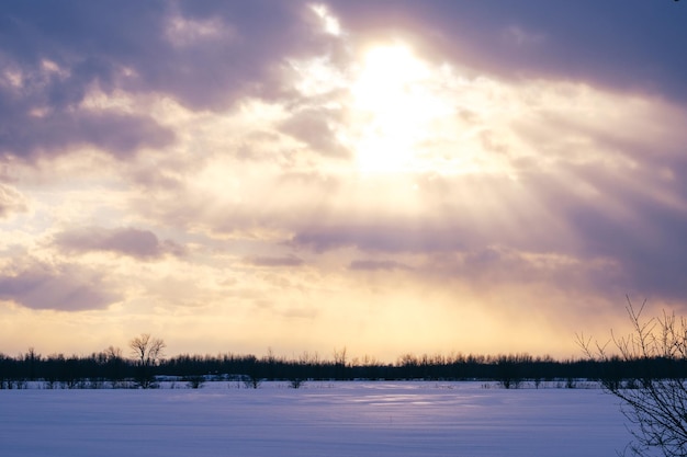 Coucher du soleil par temps nuageux sur les champs de neige près de Saint Bruno de Montarville au Québec, Canada