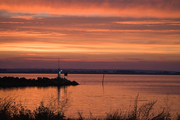 Coucher du soleil en Suède au port du phare du lac Vaettern en arrière-plan