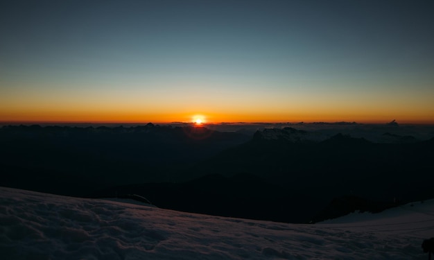 Coucher de soleil au sommet d'une montagne contre un ciel bleu clair