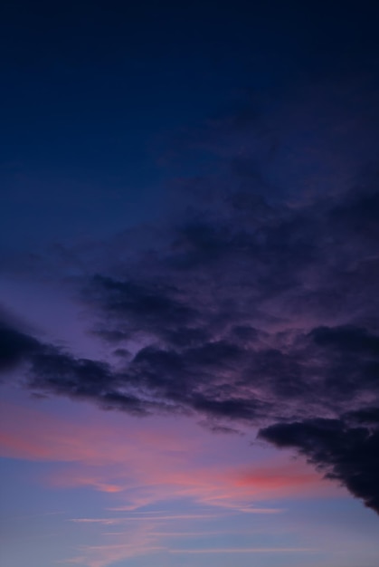 Coucher de soleil avec un ciel coloré en orange, violet et bleu foncé, crépuscule vertical le soir avec un beau ciel au crépuscule en automne