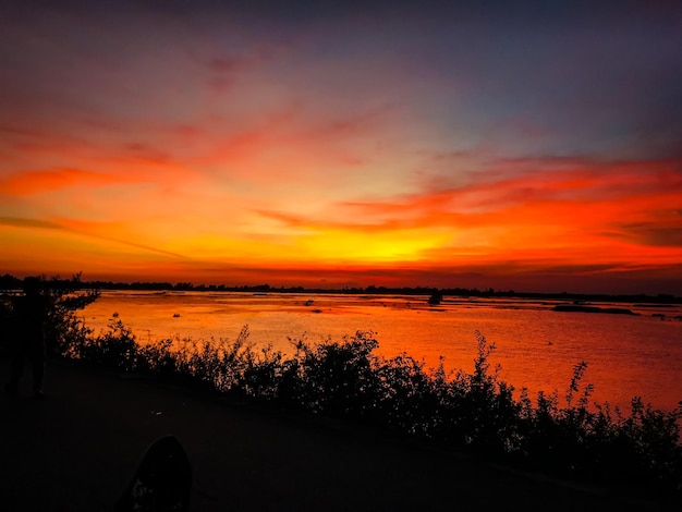 Un coucher de soleil avec un ciel rouge et le soleil se couche