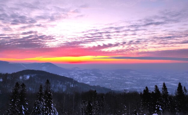 un coucher de soleil coloré est vu en arrière-plan d'une chaîne de montagnes