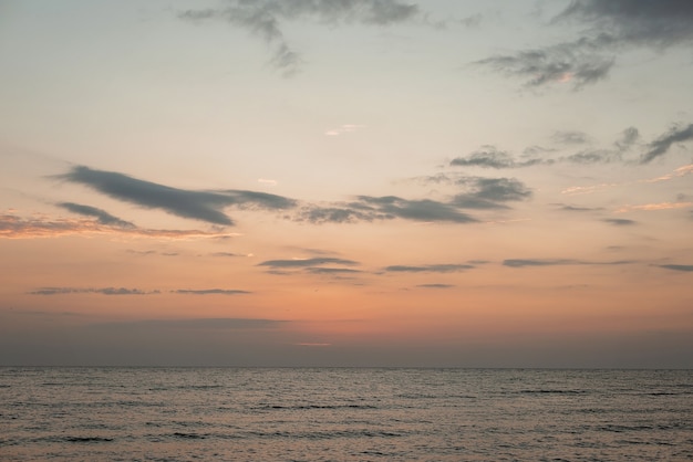 Coucher de soleil coloré sur une plage de sable, vagues avec de la mousse sur le sable. Océan, côte.